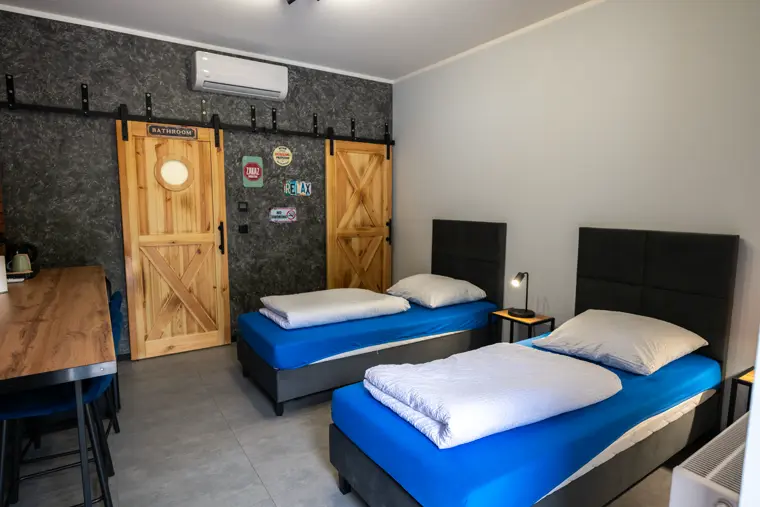 Studio z trzema łóżkami, stołem i aneksem